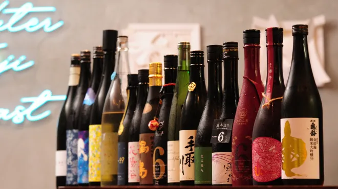 A lineup of Japanese sake bottles at the Kawasaki bar